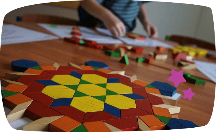 tangram in pirmo piano su tavolo e bambino che gioca giochi da fare in casa