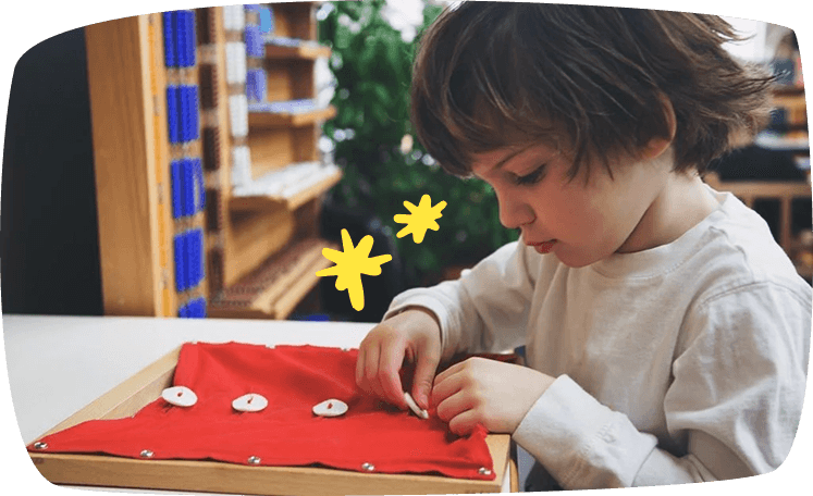 bambina abbottona su telaio montessori