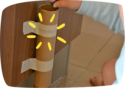 montessori bambino infila oggetto in tubo di cartone