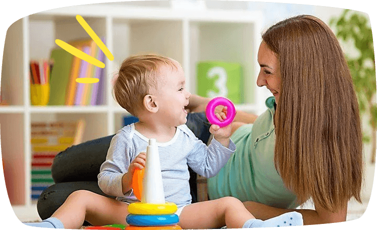 Babysitter sorride al bambino che gioca