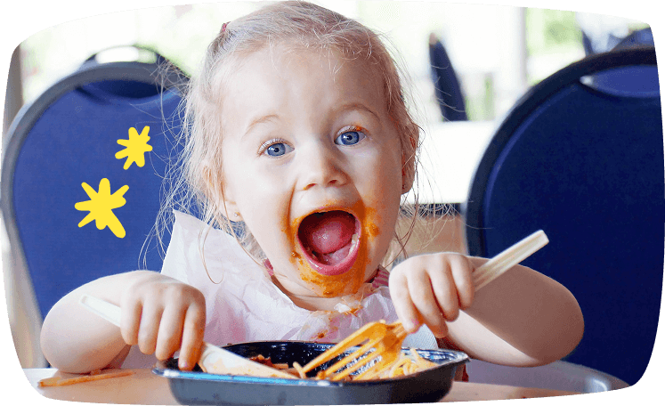 bambina mangia pasta al sugo con coltello e forchetta