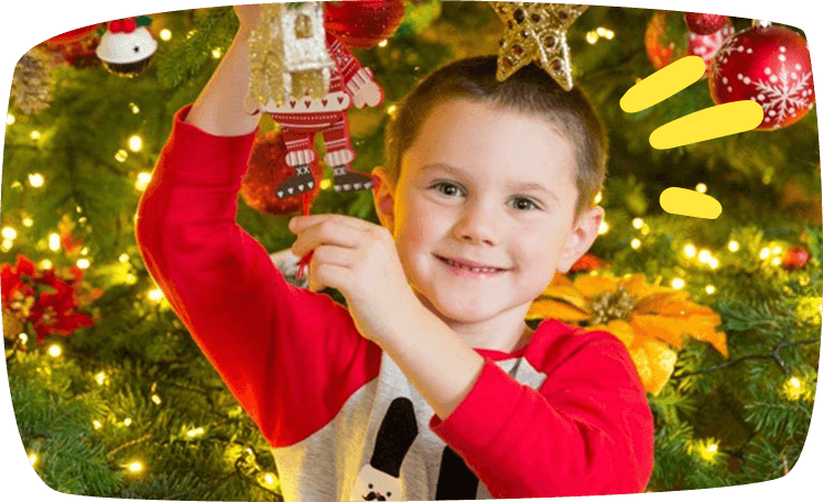 bambino appende decorazione su albero di natale