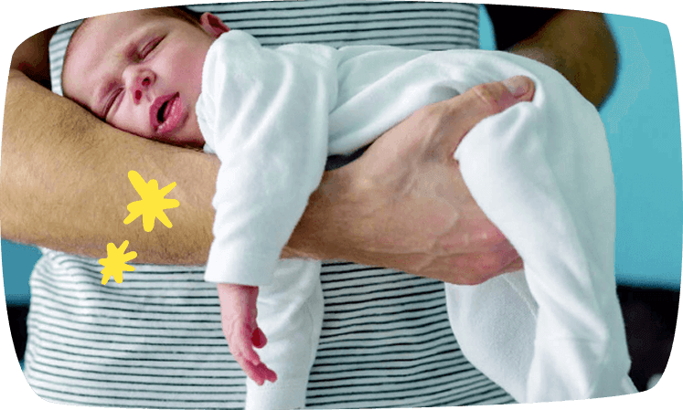 neonato adagiato di pancia sul braccio del papà